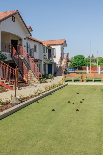 A Bocce ball lawn with a few balls on it at The Villas at Ellis Manor at The Villas at Ellis Manor, Fresno, California